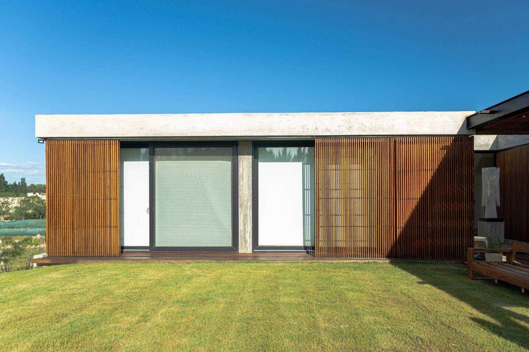 fachada con paños vidriados y tamices de madera