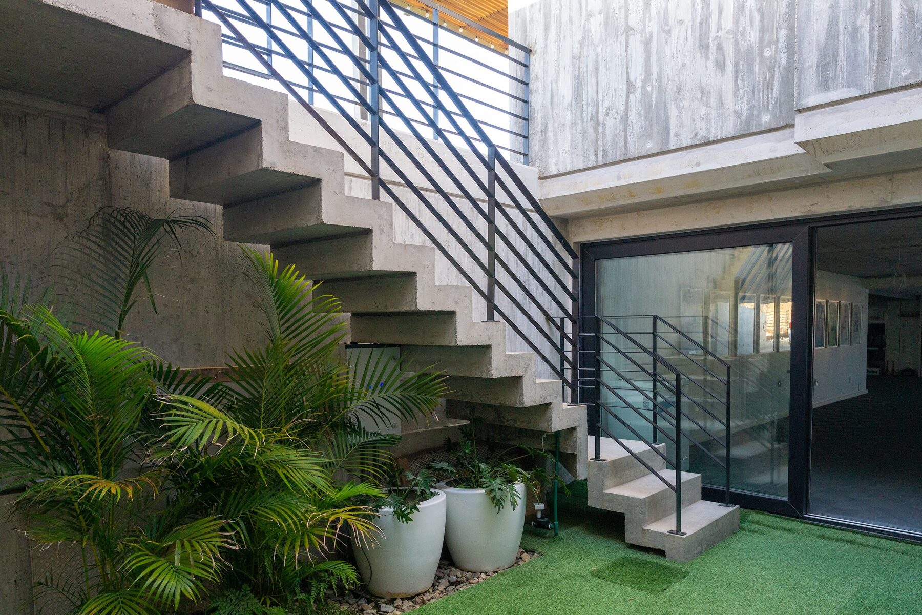 escalera exterior de hormigón junto a la galería vidriada