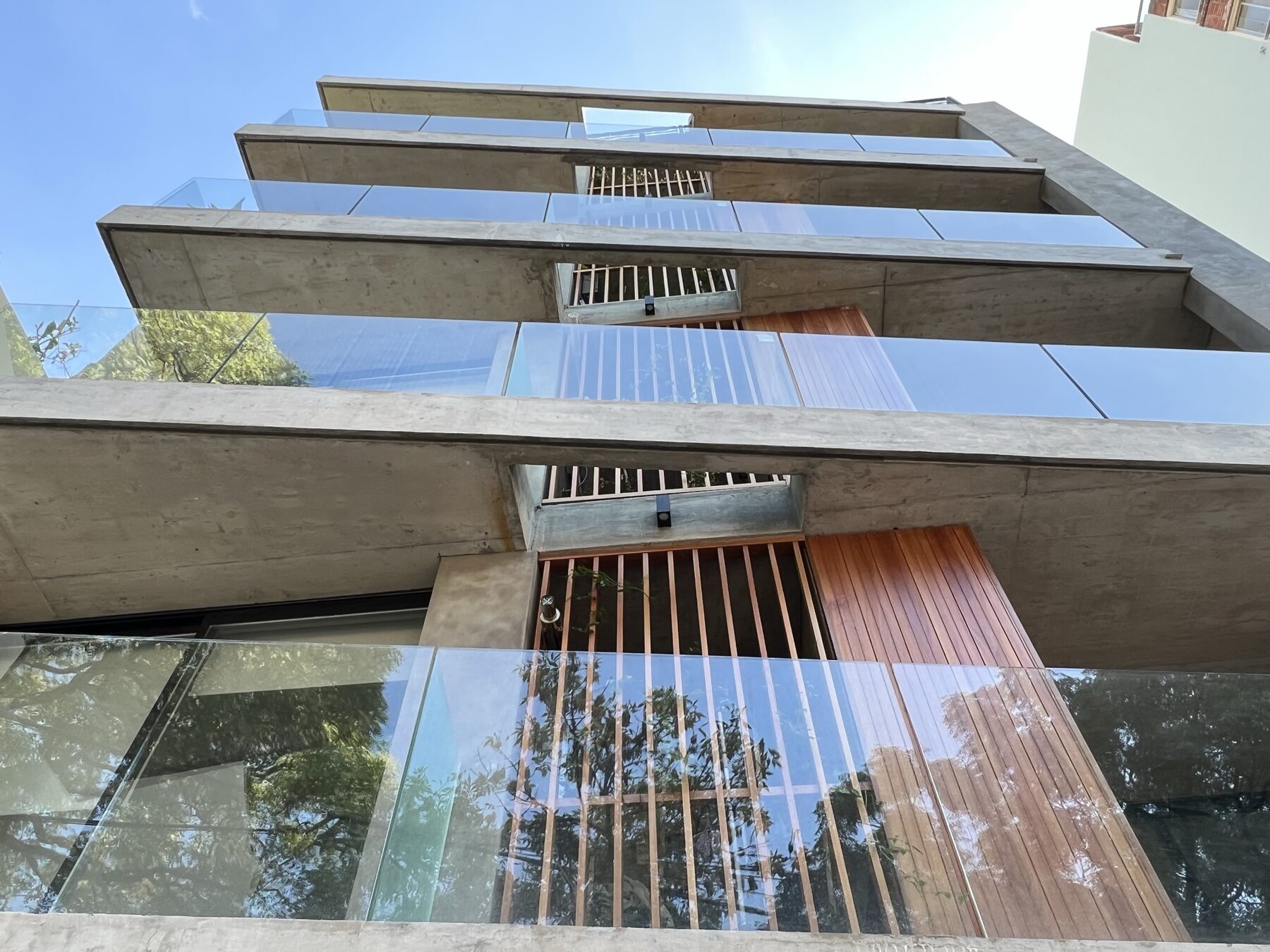 balcones de hormigón y vidrio con tamices de madera vistos desde abajo