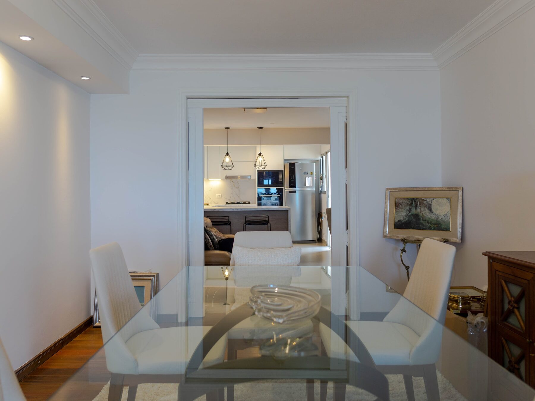 cocina blanca con mesada de mármol y luminarias colgantes
